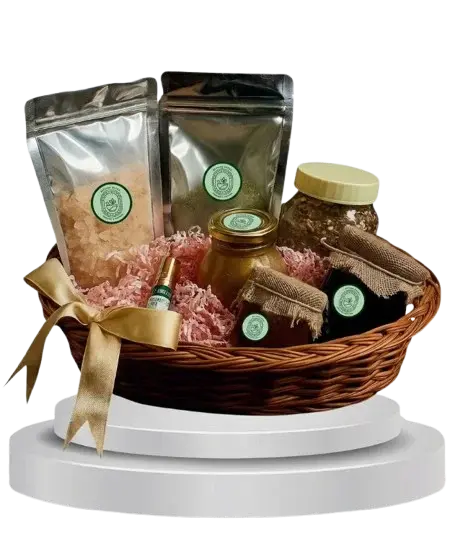 A Beyond Herba gift hamper: a wicker basket tied with a gold ribbon, holding two foil pouches, three jars and a small bottle, each carrying the Beyond Herba seal